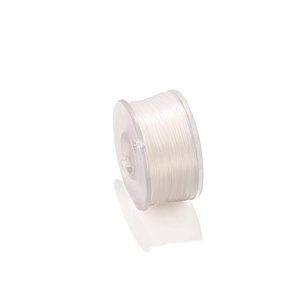 Détail macro du fil de nylon blanc 0,3mm enroulé sur une bobine en plastique clair