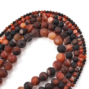 Détails de perles d'agate mate avec des motifs rayés naturels rouges, noirs et gris