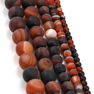 Détail macro de perles d'agate givrées aux lignes naturelles pour bijoux DIY