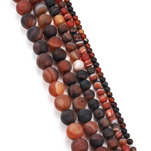 Détail macro de perles d'agate mate à rayures naturelles pour création de bijoux DIY