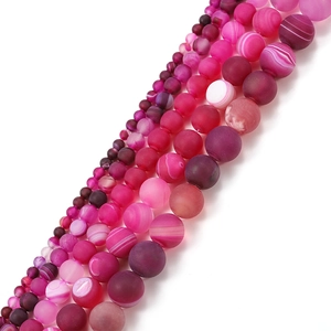 Macro shot of matte rose red striped agate beads in various sizes for DIY jewelry