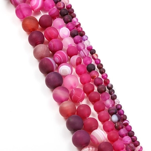 Macro shot of matte rose red striped agate beads for DIY jewelry making in various sizes