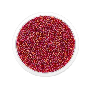 Macro shot of 2mm iridescent red glass seed beads in a clear tray for DIY jewelry