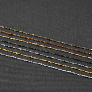 Macro detail of 1.8mm satellite cable chains in five metallic finishes on dark background