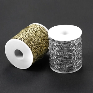 Detail von 1,5 mm Gold- und Silberketten auf weißen Spulen für DIY-Schmuckherstellung