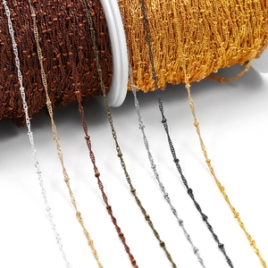 Detail of 1.8mm flat O-link chain with beads in multiple metallic colors on spools