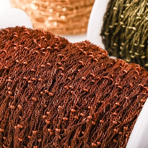 Detailed macro view of satellite bead chain rolls for jewelry making in various finishes