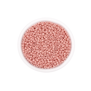 Close-up van lichtroze glazen kralen voor DIY sieraden in een ronde plastic verpakking