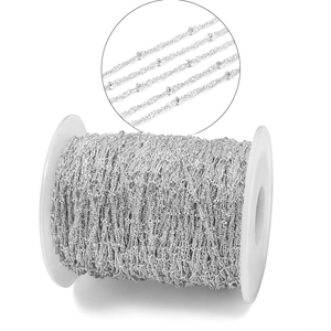 Macro detail of 1.8mm silver satellite chain for DIY jewelry making on white spool