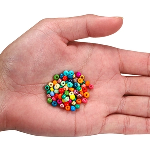 Gekleurde glazen kralen in de hand tonen klein formaat voor DIY sieraden maken