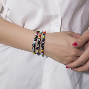 Trois bracelets en perles acryliques colorées avec perles Love et Do It sur le poignet