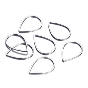 Detalle macro de siete monturas metálicas plateadas en forma de gota para pendientes DIY