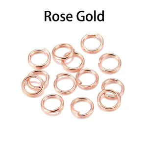 Macro view of 12 rose gold jump rings for DIY jewelry making on white mirror background