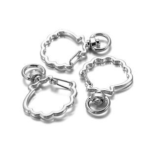 Close-up of three silver shell-shaped lobster clasps with rotating rings on white background