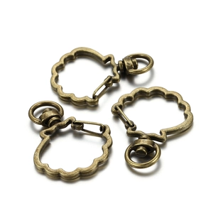 Close-up of three bronze shell-shaped lobster clasps with swivel rings for DIY keychains