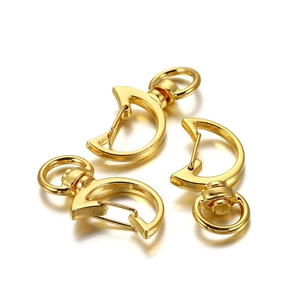 Detailed view of three golden moon-shaped lobster clasps with rotating swivel rings