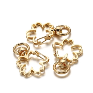 Macro detail of three golden cherry blossom lobster clasps with 360-degree swivel rings