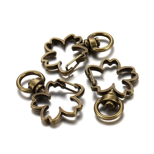 Macro detail of three bronze cherry blossom lobster clasps with rotating D-rings