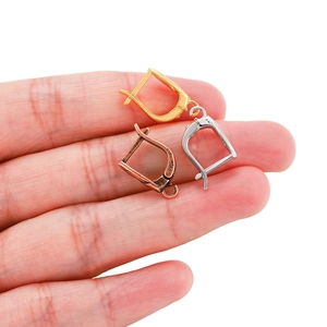 Detail of DIY French earring hooks in gold, silver, and bronze finish held by fingers