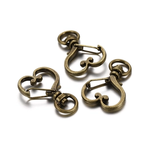 Macro shot of three heart-shaped lobster clasps in vintage bronze finish for DIY jewelry