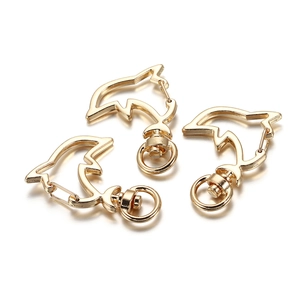 Detailed view of three gold dolphin-shaped lobster clasps with 360-degree swivel rings