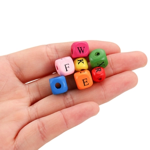 Détail de perles de bois colorées avec lettres de l'alphabet pour bijoux DIY