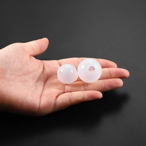 Detailed view of two sizes of spherical silicone molds held in hand for size comparison