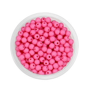 Close-up of bright pink acrylic round beads with holes in a clear storage container