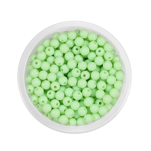 Detailed top view of 6mm light green acrylic round beads with holes in a clear container