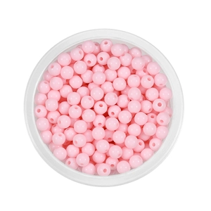 Macro shot of 6mm pink acrylic spacer beads in a clear box for DIY jewelry making