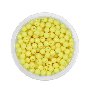 Close-up of 6mm light yellow acrylic round beads in a clear container for DIY jewelry
