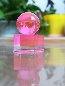 Macro view of a pink translucent resin cube and sphere with elegant light refraction