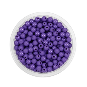 Macro shot of 6mm purple acrylic beads in a round tray for DIY jewelry making