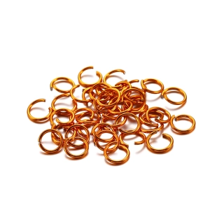 Macro detail of orange aluminum open jump rings for DIY jewelry making accessories
