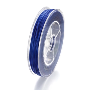 Détail du fil élastique en cristal bleu foncé enroulé sur une bobine en plastique