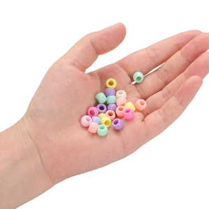 Bunte Acrylperlen in Bonbonfarben mit großen Löchern für DIY-Schmuck in der Hand gehalten