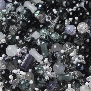 Macro shot of mixed black and white beads with crackle and matte textures for DIY jewelry