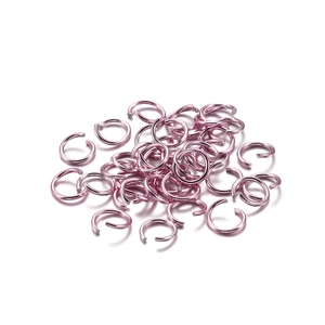 Detailed view of pink aluminum jump rings for DIY jewelry making and bracelet assembly