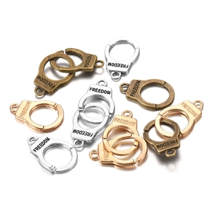 Detailed view of mini handcuff pendants with Freedom engraving for DIY keychains