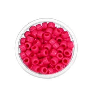 Draufsicht auf rosa Acrylperlen mit großen Löchern in einem klaren Behälter