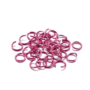 Detailed pile of vibrant rose pink aluminum open jump rings for DIY jewelry making