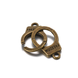 Macro shot of bronze metal handcuffs charm with engraved FREEDOM text for DIY jewelry