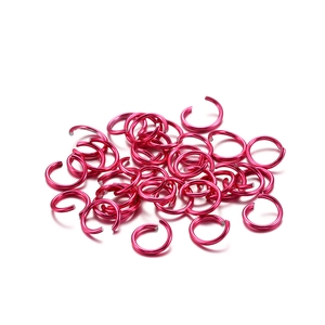 Detailed close-up of rose red aluminum jump rings for DIY jewelry making and bracelet repairs