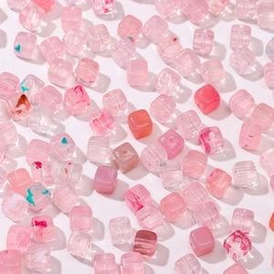 Vista macro de cuentas cuadradas de acrílico rosa para la creación de joyas DIY