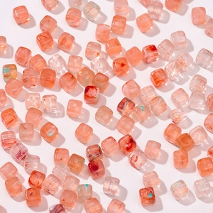 Detalle de cuentas cuadradas de acrílico rosa y melocotón con textura de mármol para DIY