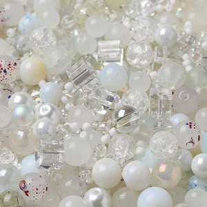 Macro view of assorted white and translucent beads with various textures for DIY crafting