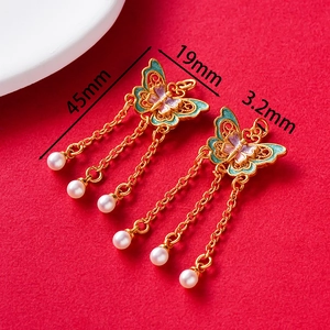 Detail of vintage butterfly tassel earrings with colorful enamel and pearl drops