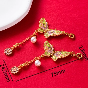 Detail of vintage butterfly pendants with enamel colors, white pearls and gold chain