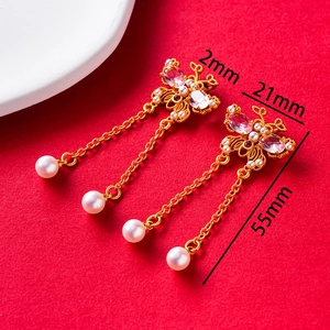 Detailed view of butterfly earrings with pink gems and white pearl tassels showing 55mm length