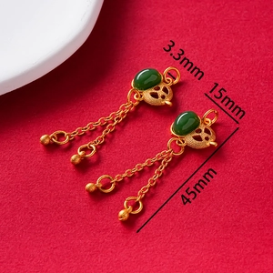 Detail of vintage gold tassel pendant with green jade and hollow cloud pattern